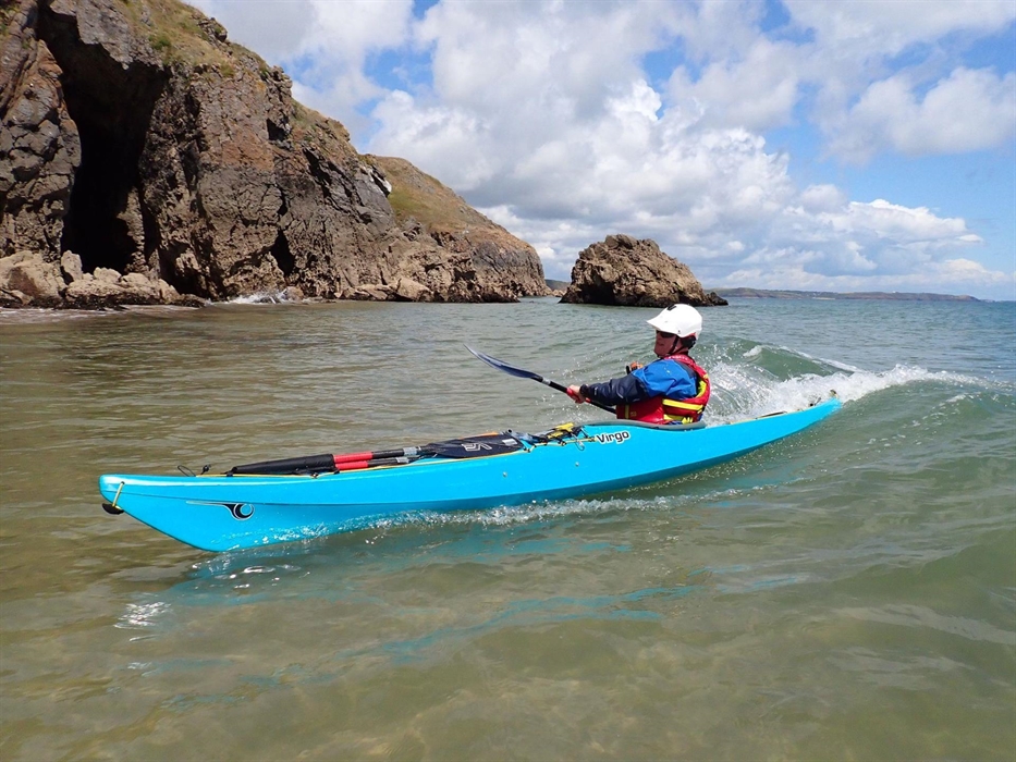 Sea kayaker surfing in small surf