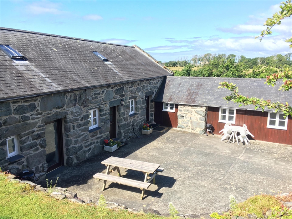Two attached stone cottages converted from farm buildings with a patio formed from the old farm yard