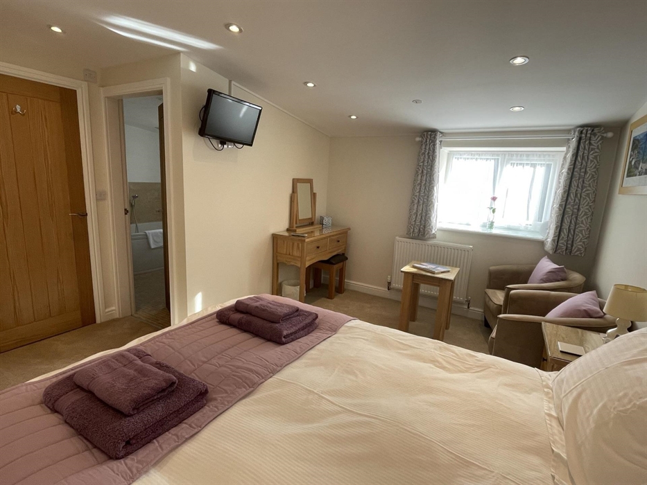 with 5' king bed, seating area, TV with DVD player & full en-suite bathroom