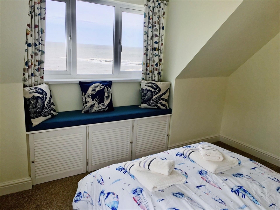 double bedroom wiht window seat and extensive sea views