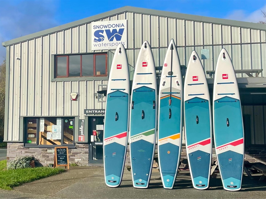 Picture of Snowdonia Watersports shop with a row of paddleboards on display.