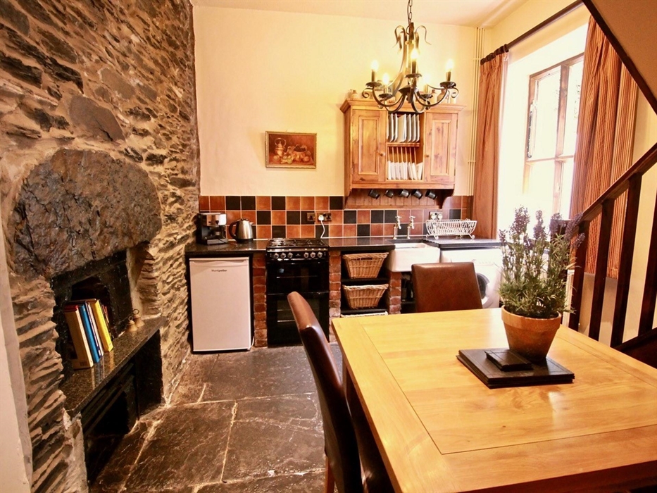 Kitchen with oven, dishwasher, fridge and freezer, microwave  on original slate floor.  Granite top and feature original fireplace