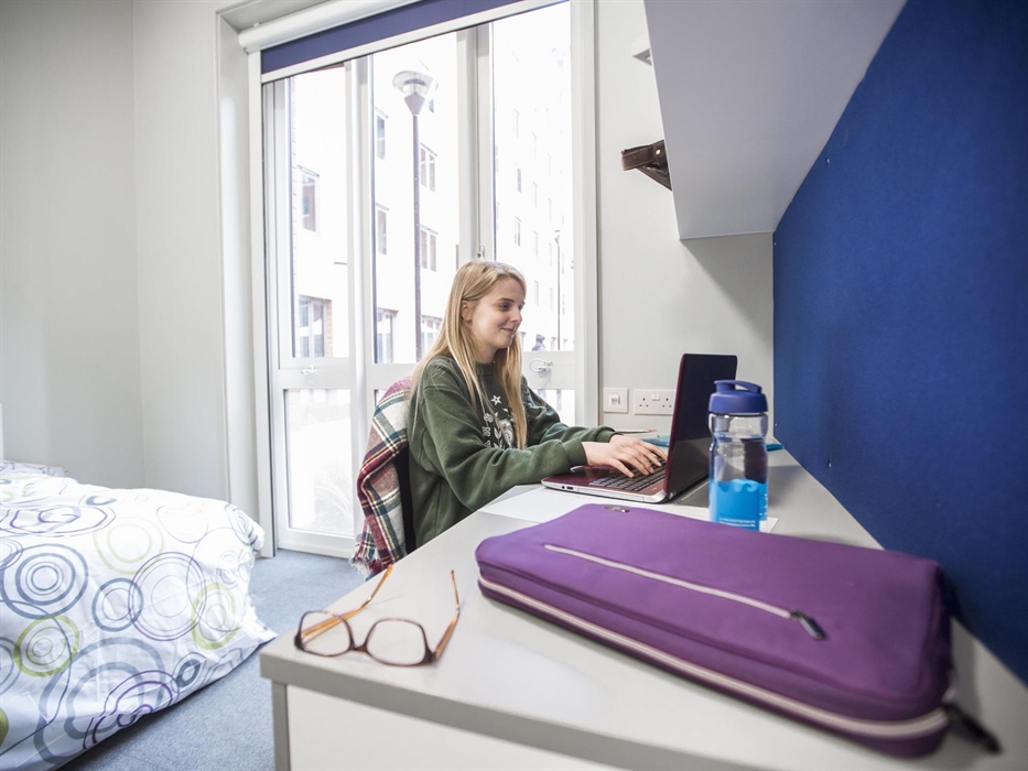 Female student smiling in bedroom on bay