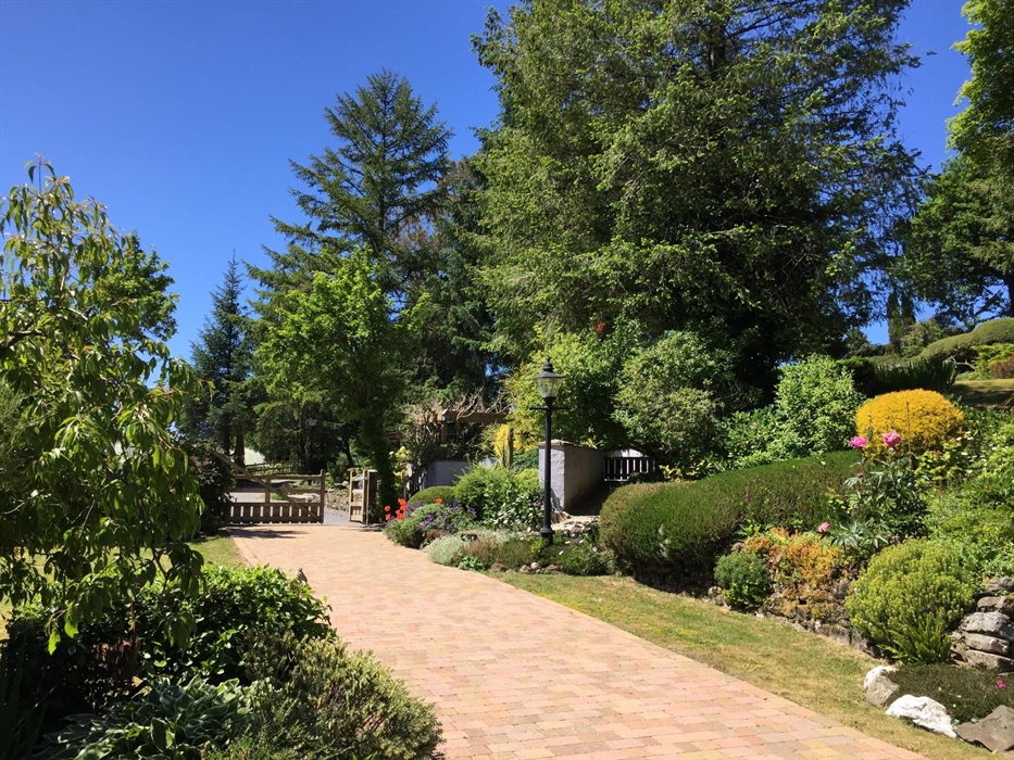 View from the garden room across the gardens, wonderful shrubs and manicured lawns.