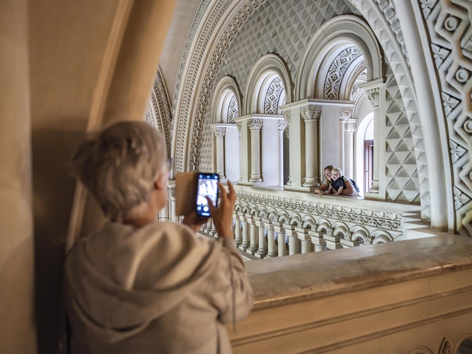 Families pose for pictures at the top of the intricately carved Grand Hall.