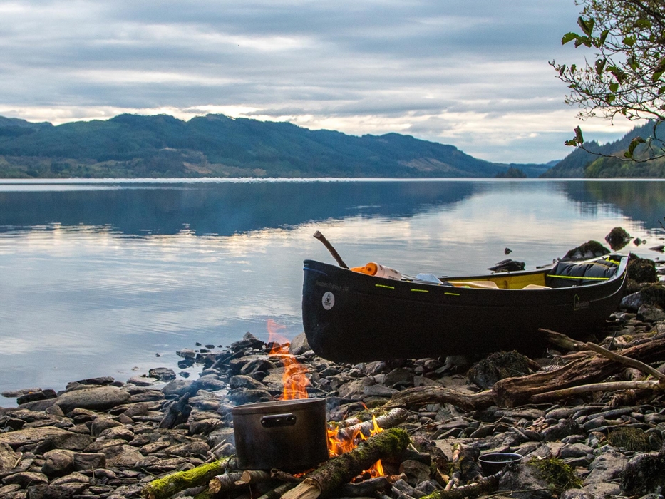 Bearded men adventures, Canoe on a Loch in Scotland next to a camp fire