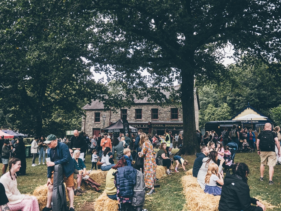 A crowd of people sitting on hay bales on Gwalia Green