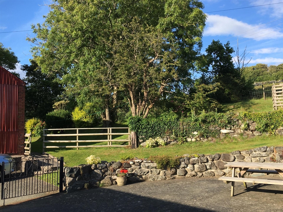 Outdoor seating area with trees and stone wall