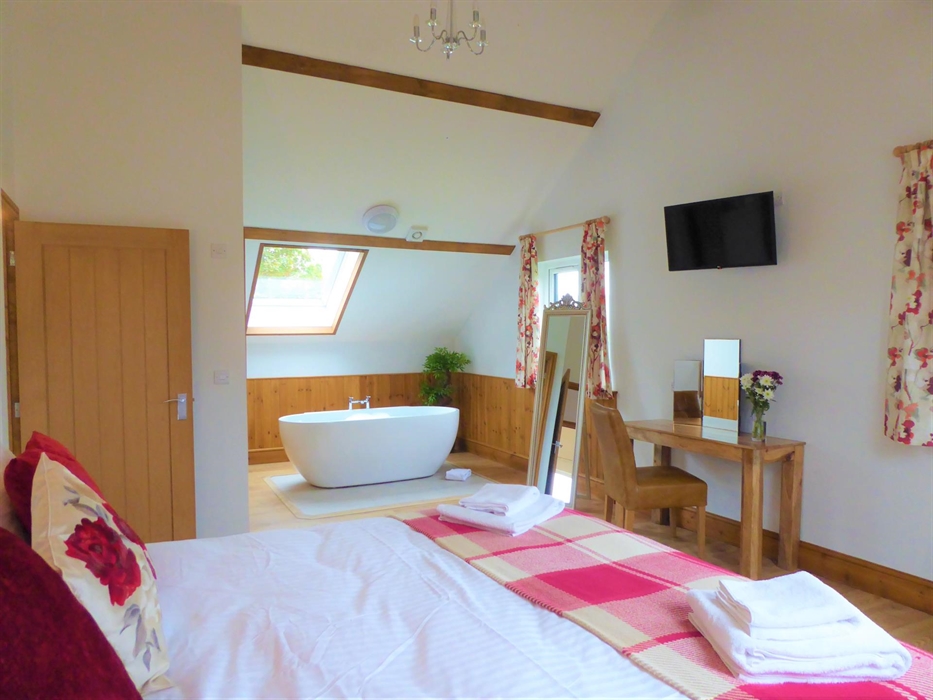 Bedroom 2 (upstairs) with superking size bed or 2x single beds smart tv and freestanding bathtub.  Adjoining is an ensuite room with walk in shower.