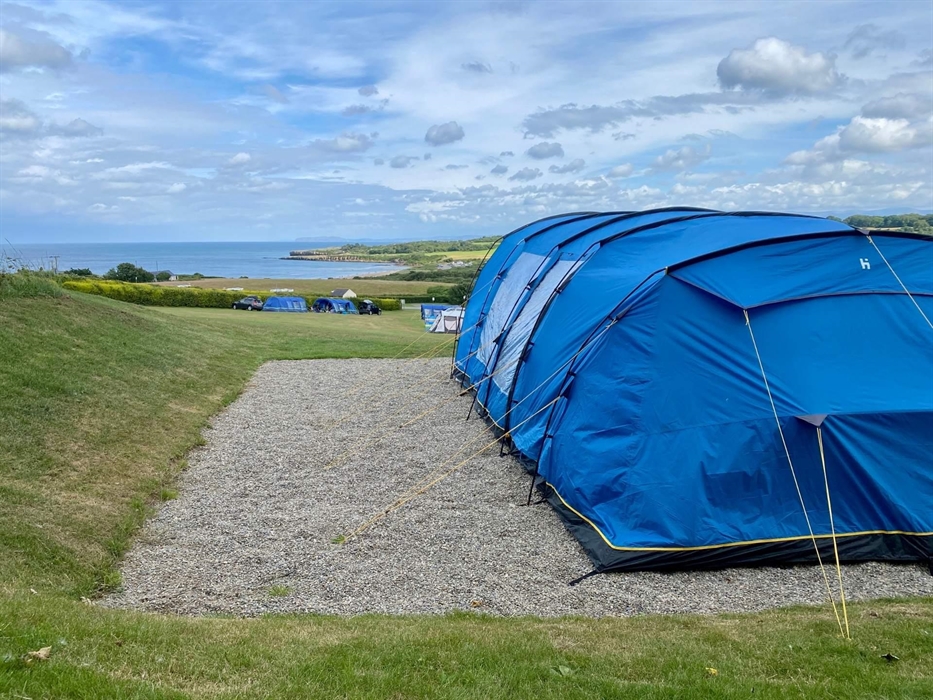 Level all-weather pitches with superb sea views looking over Lligwy Bay towards the Great Orme and Snowdonia.