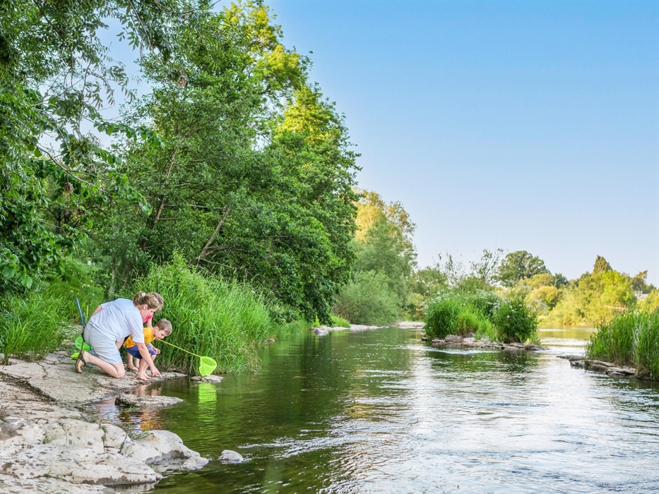 A family fishing in a river with nets