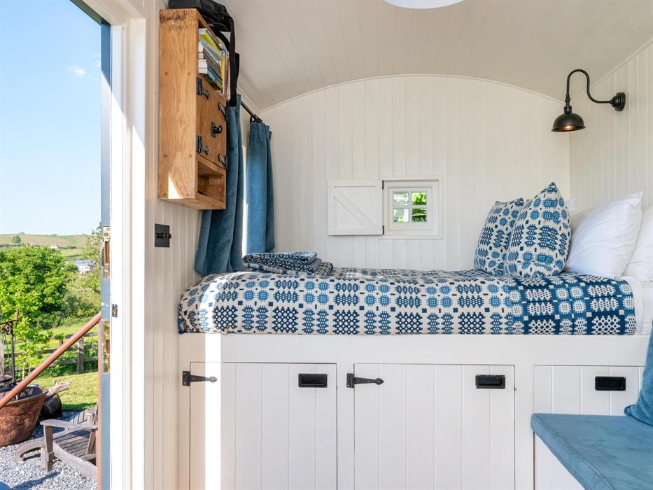 King-size bed with comfortable handmade mattress, handwoven traditional Welsh blankets and throws .