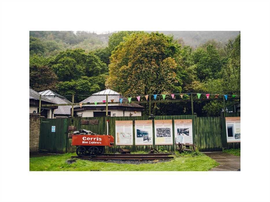 An old slate truck and information boards outside of Corris Mine Explorers based at Corris Caverns in Mid Wales