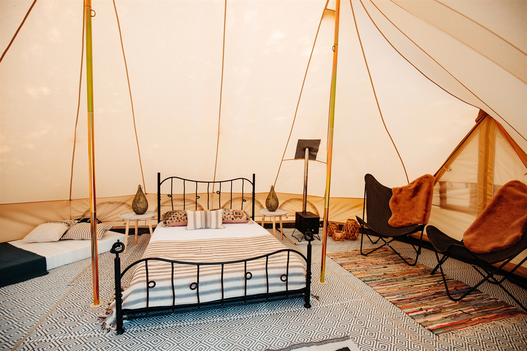 Inside a furnished pre-pitched canvas tent, double bed, two chairs - bohemian style
