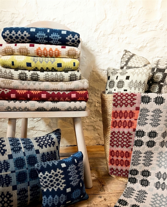 Colourful woven blankets and pillows on a stool