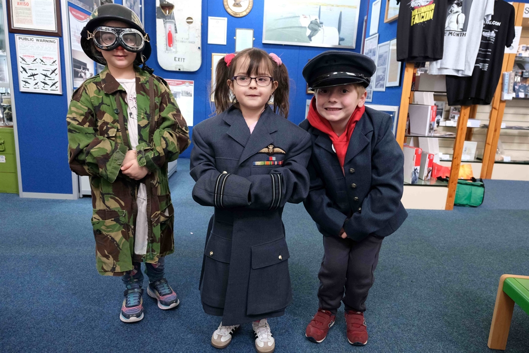 Three children enjoying dressing up in uniforms from our rummage box