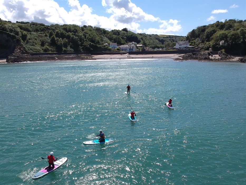 Group of five paddleboarders on the sea in a sheltered bay