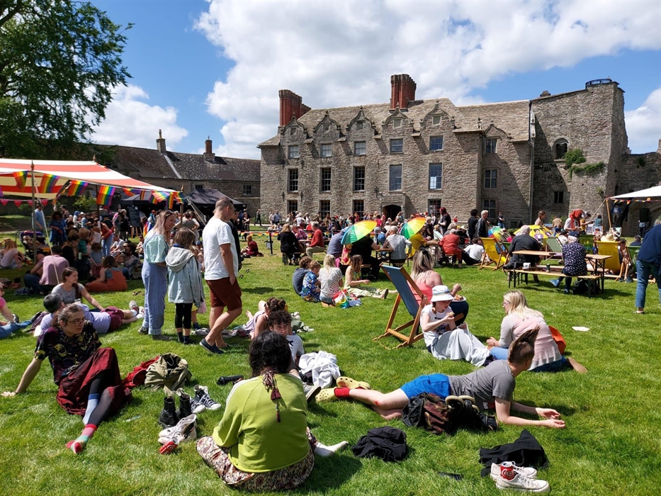 The photo shows visitors enjoying the lawns at Hay Castle during the Hay Pride event June 2022