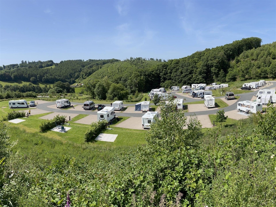 A panoramic view of Red Kite Touring Park under blue skies.