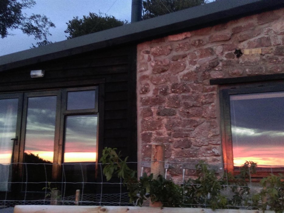 The front of the Top Barn reflecting one of the glorious sunsets from The Kymin
