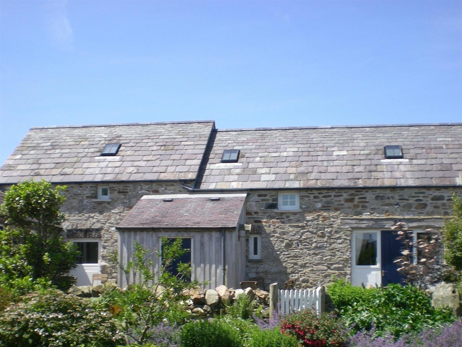 The stone walls and slated roofs make a beautiful scene set behind the farmyard garden.