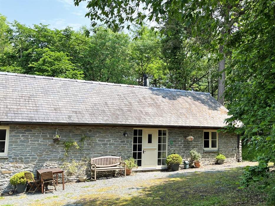 The front of Drovers Retreat stone cottage with trees behind