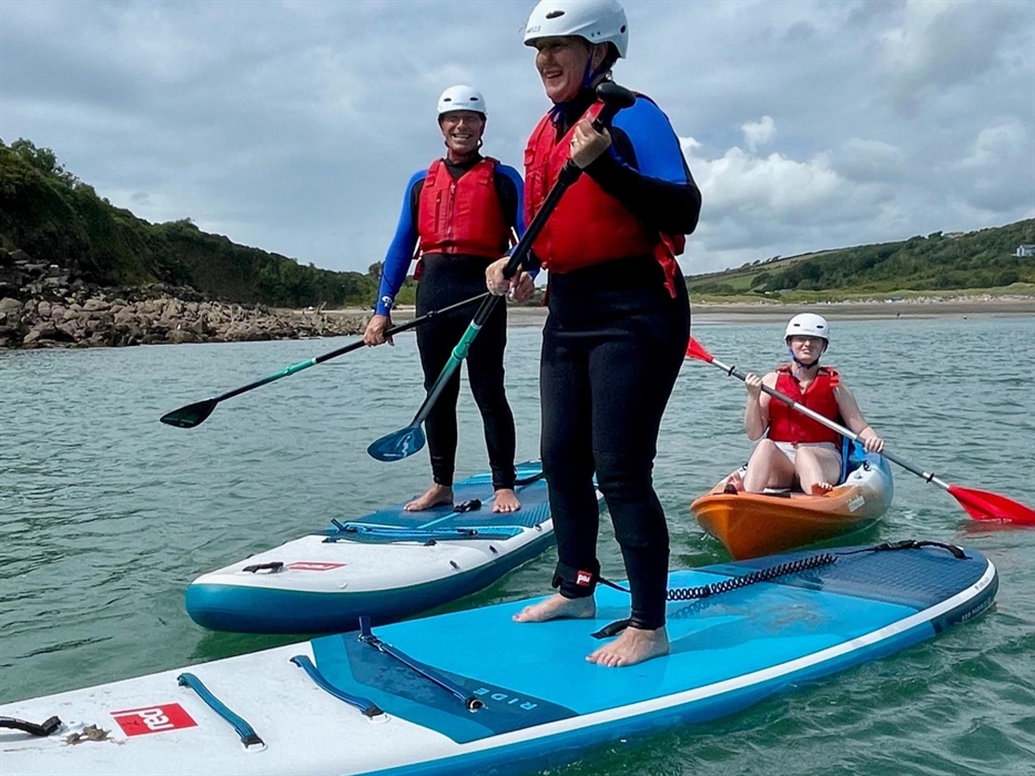 Family paddleboarding and kayaking in a sheltered bay
