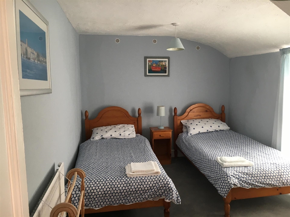 Bedroom decorated in pale blue with two single beds