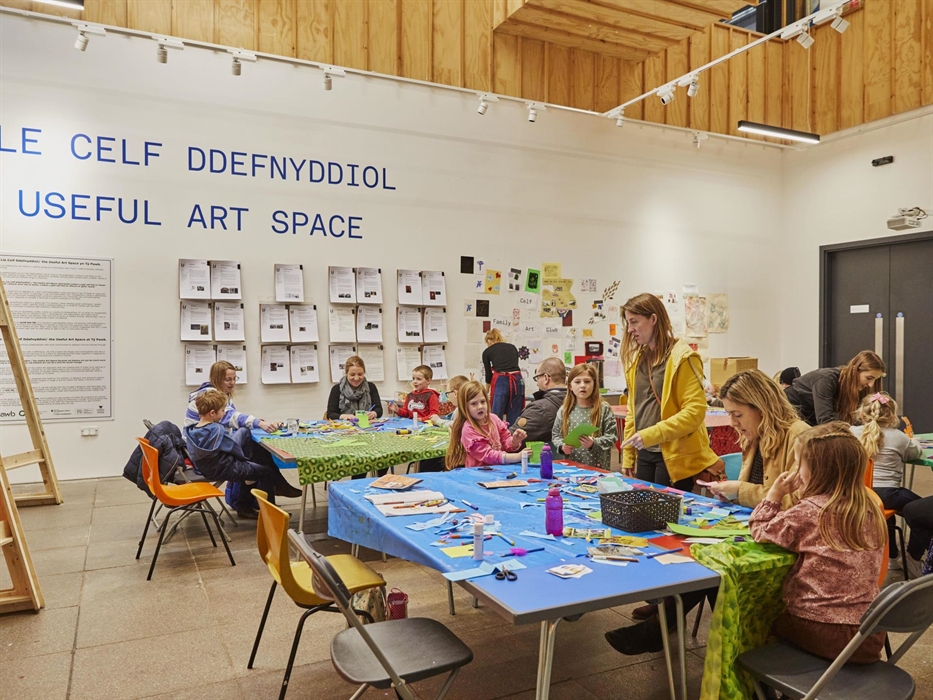 Tŷ Pawb's Useful Art Space, with children sat at tables taking part in craft activity