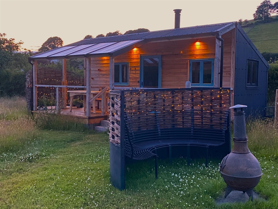 Handbuilt cabin with outdoor bath, set in an enchanting meadow, edge of the historic village of Llanfihangel y Creuddyn in Wales.