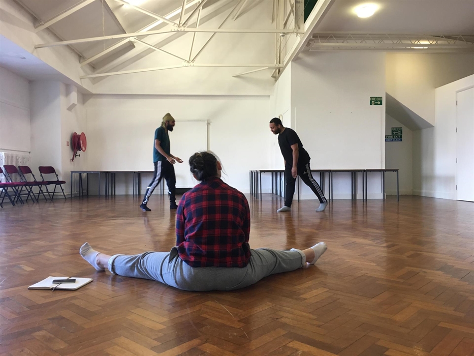 Three dancers, one sat watching, in rehearsals in the Oriel/Gallery space