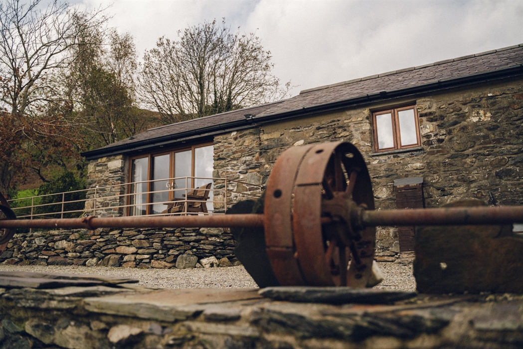 Ty Felin exterior with patio area and 17th Century water mill cog