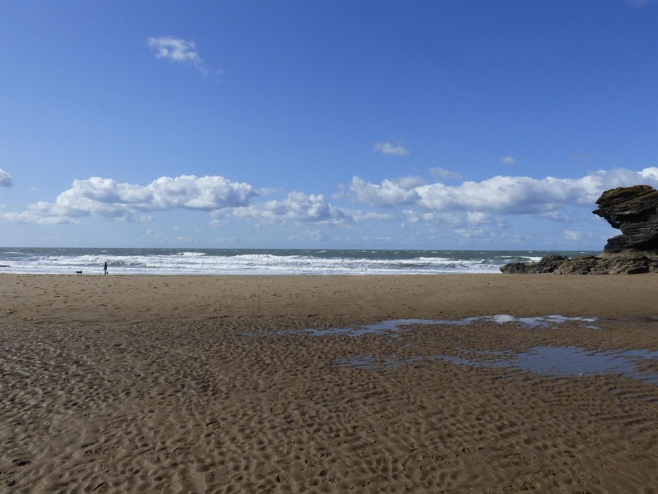 Llangrannog beach at low tide. Blue sky, puffy clouds, big waves