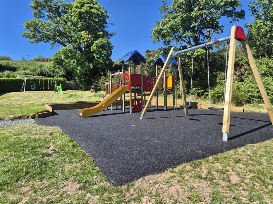 Play park showing swings, a slide and climbing frame