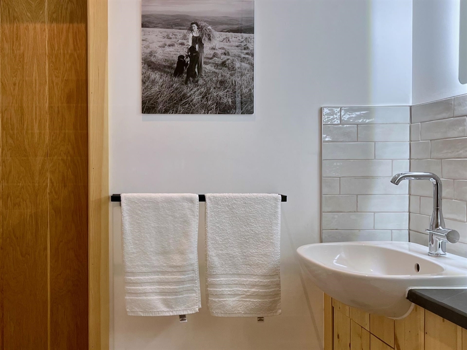The shower room is bright and clean with tiling around the basin and natural slate surfaces