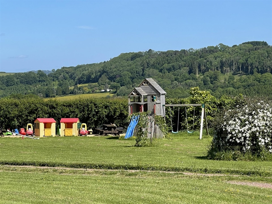 Children's play area with climbing tower, rock wall, slide and twin swing set. Also spring rocker and a range of other outdoor toys.