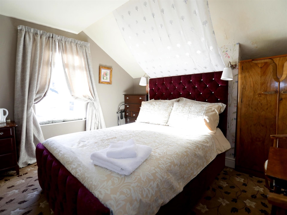 Relax on the window seat, where you can watch the world pass by or delve into your favorite novel in this special room adorned with charming eaves.