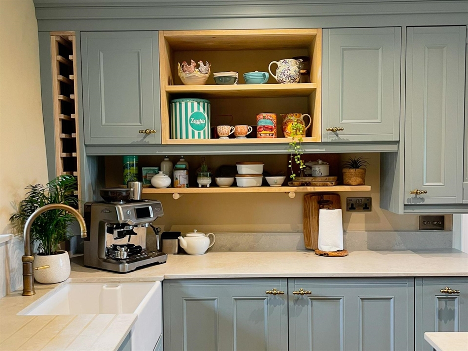 The kitchen at seadog and stone ysgubor degwm. blue units with concrete style work tops. Belfast sink, brass quooker tap and sage coffee machine