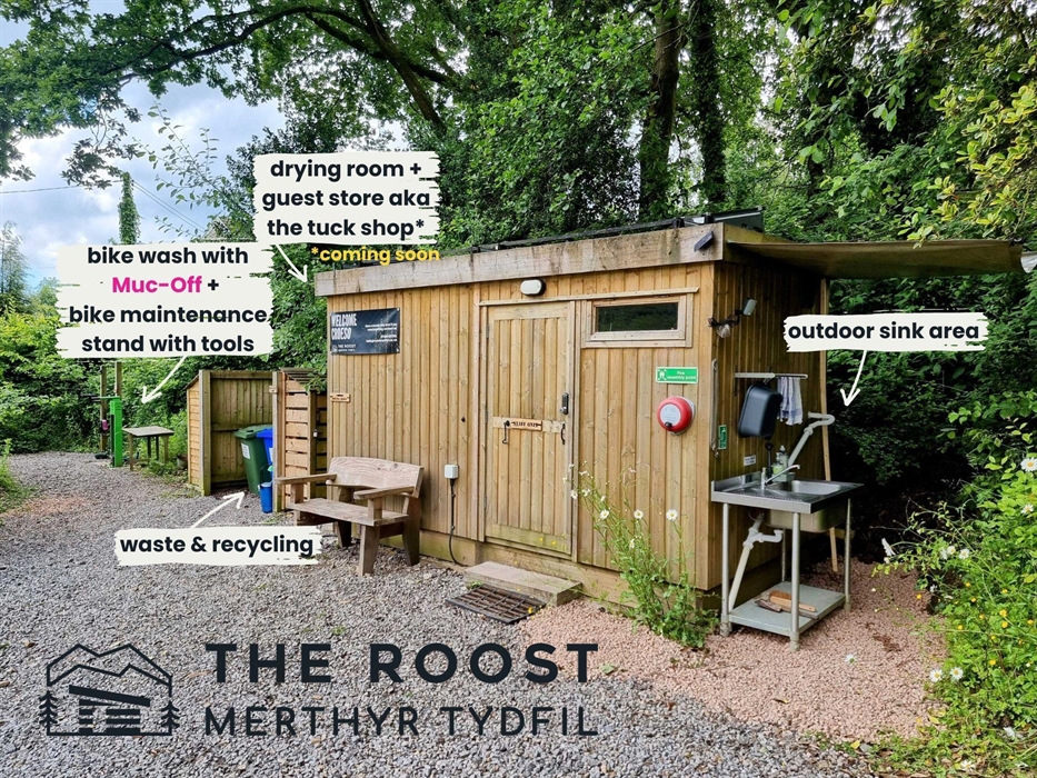 A wooden cabin in the trees with sink and facilities with name labels