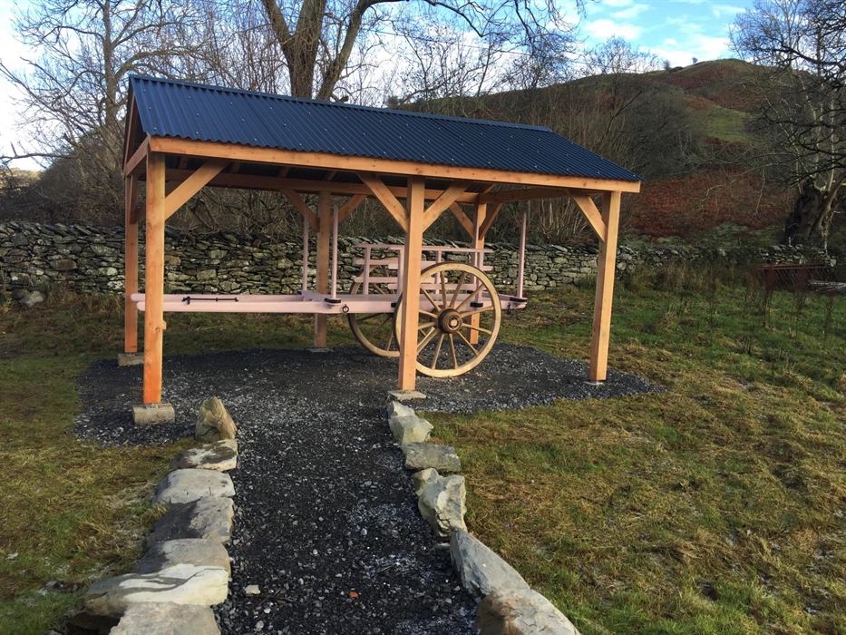 Traditional restored gambo cart beneath a small timber and metal open shed
