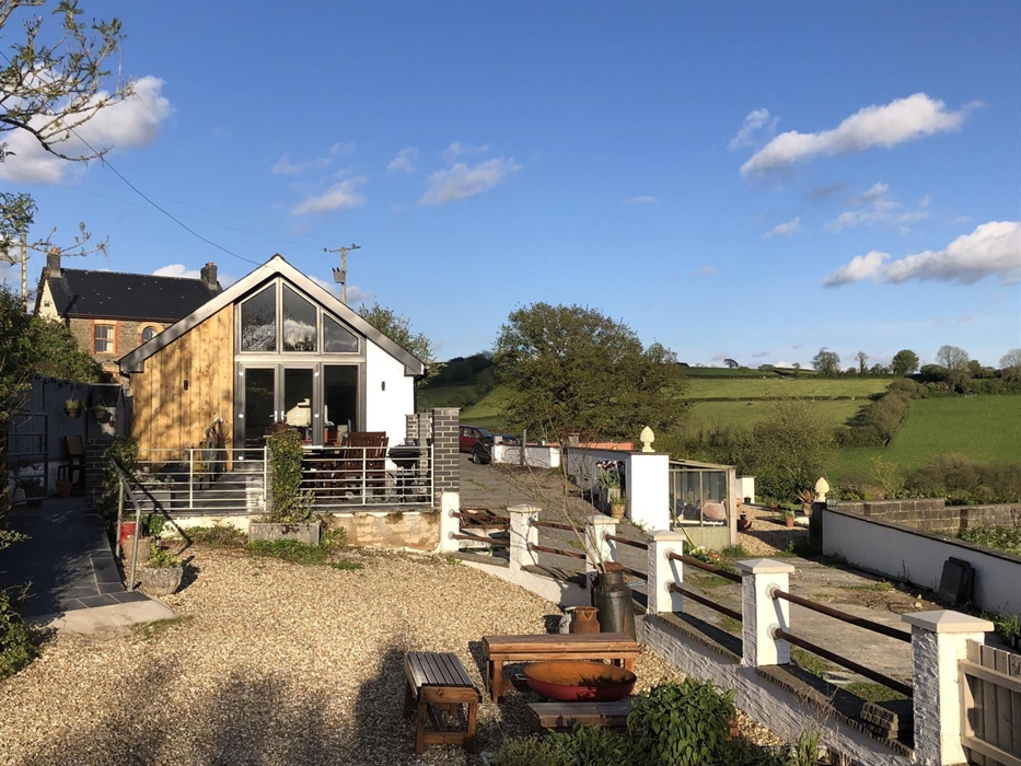 Enjoy all seasons with raised sun trap patio with dining table and chairs , parasol, bbq , storage shed ,or sit round a fire pit on gravelled area bel