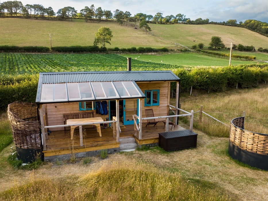Handbuilt cabin with outdoor bath, set in an enchanting meadow, edge of the historic village of Llanfihangel y Creuddyn in Wales.