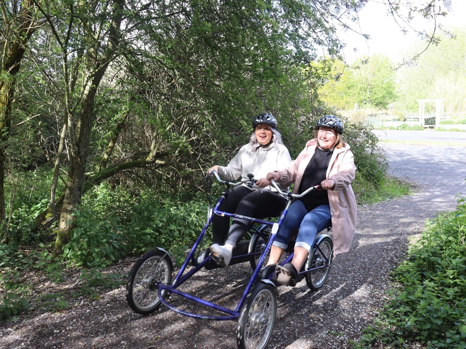 Two women riding a side by side bike