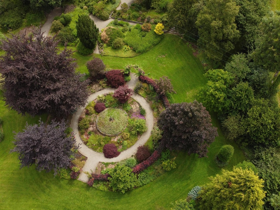 The circular red garden as seen from above, shows the round gravel path with round beds either side of it. The overwhelming colour here is purple foli