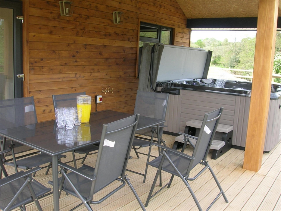 The 6 seater Hot Tub along with a dining set on the decking area at River Lodge.