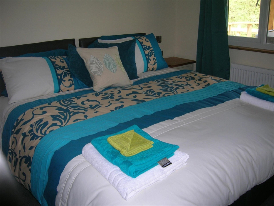 The en suite bedroom looks out onto the cover decking area and hot tub.