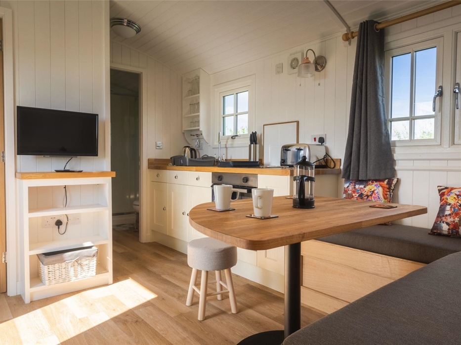 Dining table, bench seating and galley kitchen with fairground styling