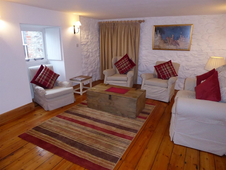 Warmly coloured checks and stripes furnish this spacious sitting room.