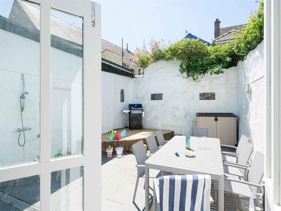 The sunny courtyard is equipped with a barbecue, outdoor shower and outdoor seating, perfect for al fresco dining