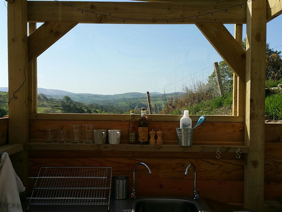 The sink and drainer in the outdoor kitchen with a stunning blue sky and rolling green hills of North Wales.